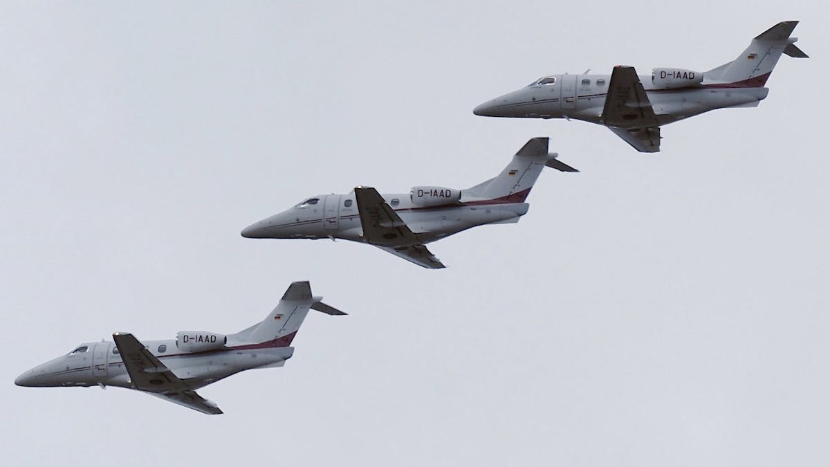 Three Embraer Phenom 100 private jets photoshopped above each other while flying.